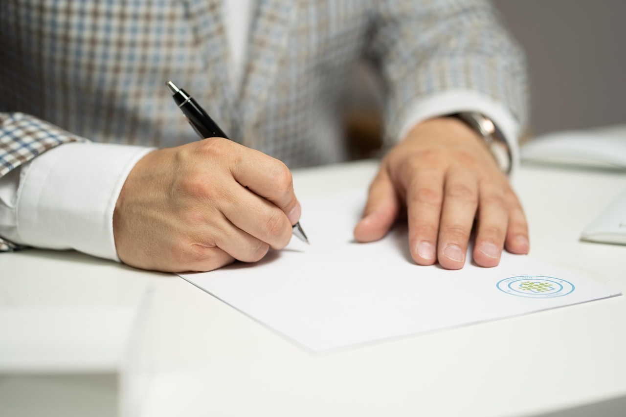 signing paper document contract agreement pen